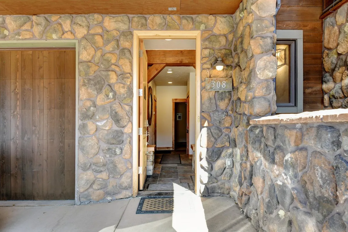 This exterior image features a welcoming stone wall, front door, and house number, providing a glimpse of the villa's inviting entrance. The scene suggests a sense of arrival and hints at the tranquility within.